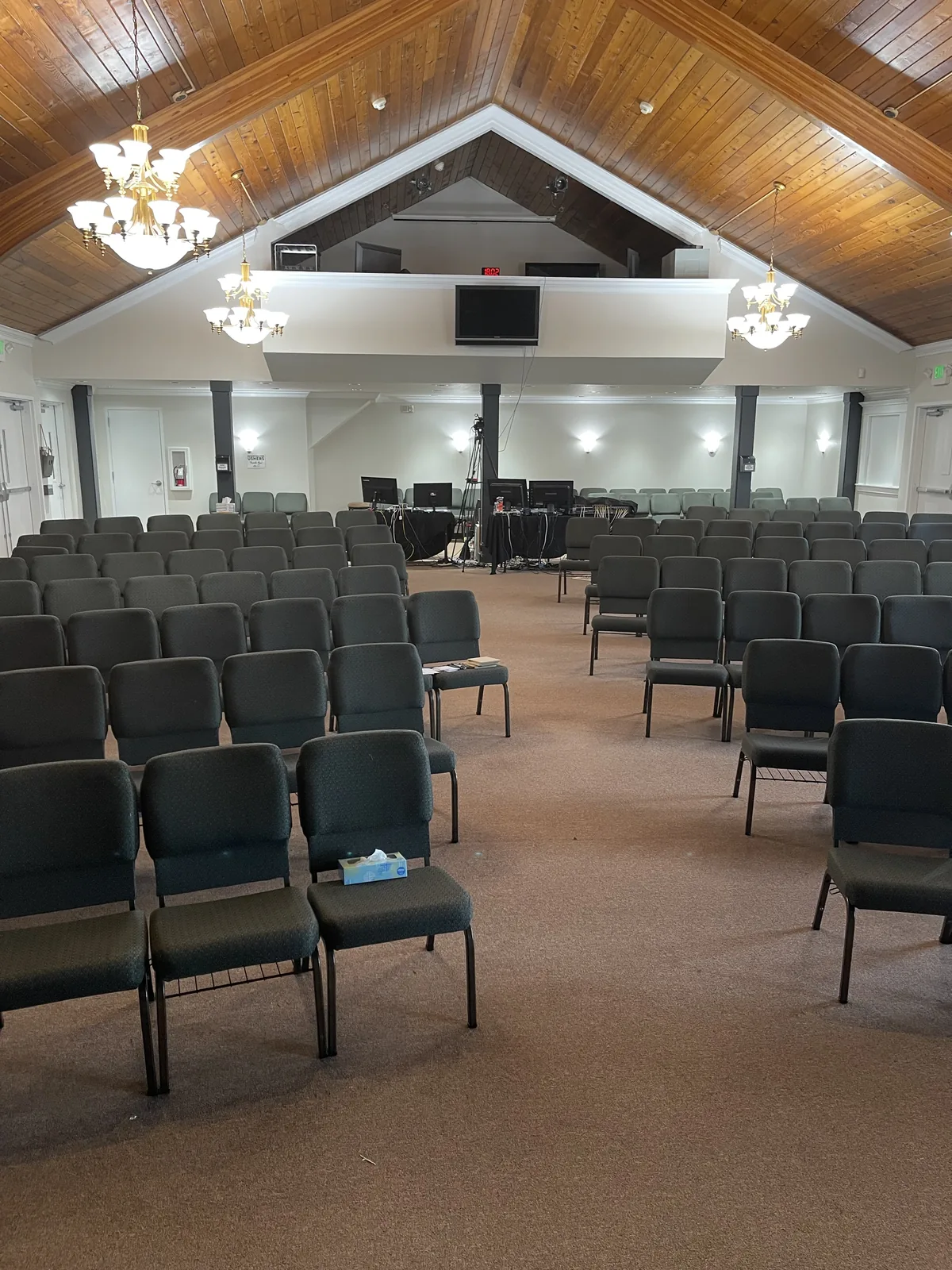 Church sanctuary with a repainted wood cathedral ceiling and rows of seating