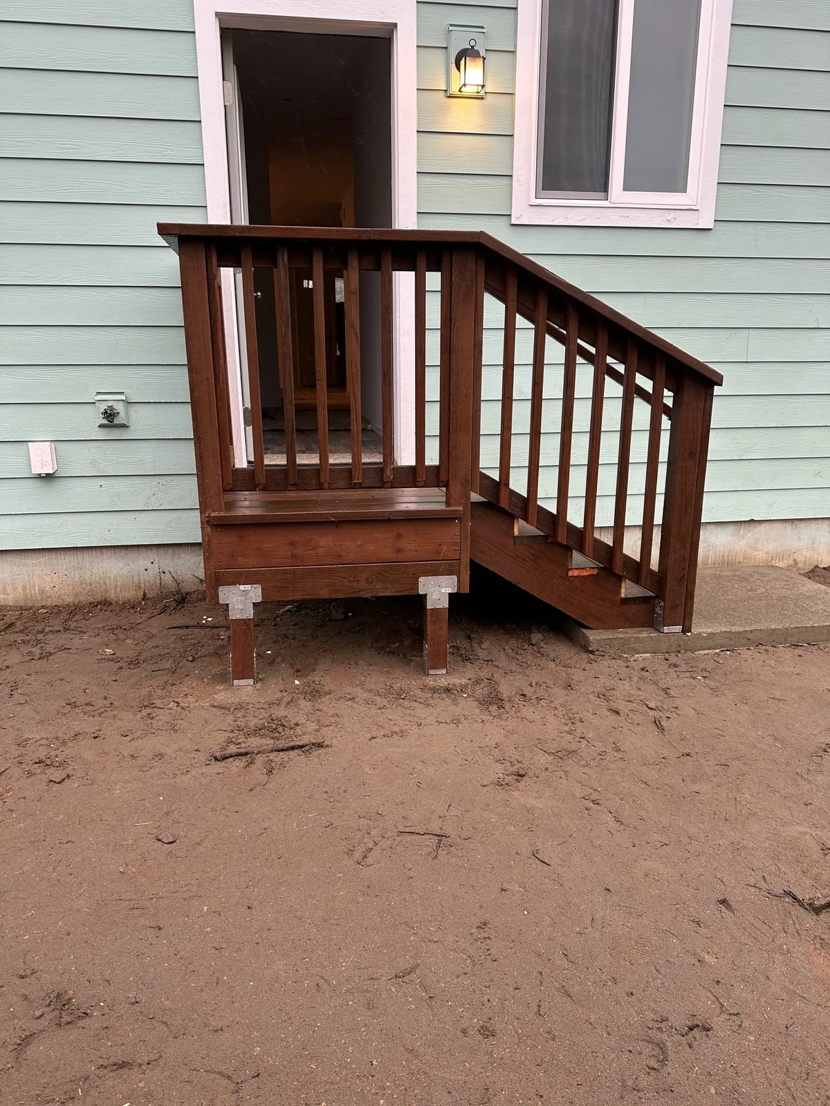 Freshly built and stained wood entry landing with railing and steps