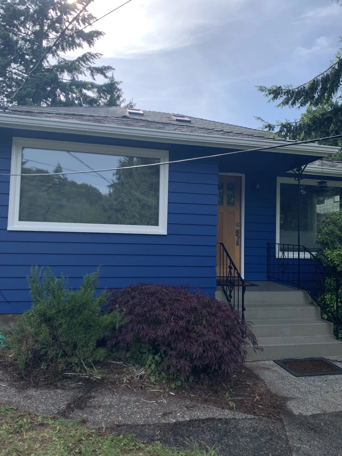 Two-storey home with a fresh greige exterior repaint and white trim